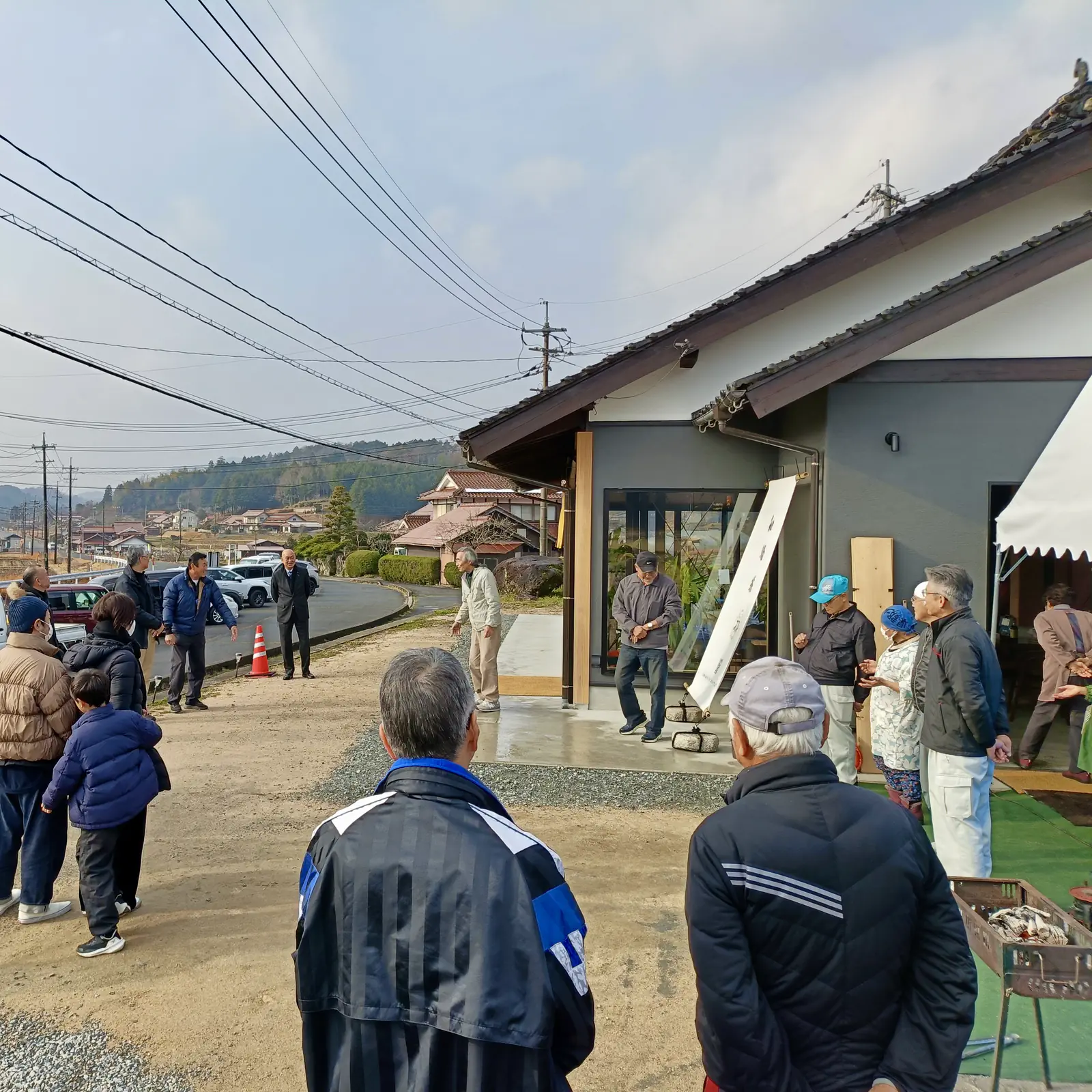 コミュニティセンター「わっ」の前に集まった人たち。軒先やテントのまわりに、大人も子どもも立っている